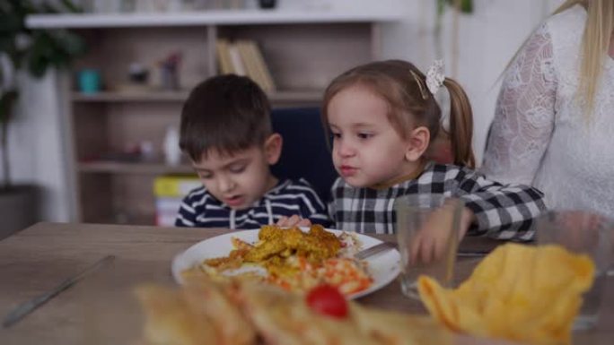 孩子们在朋友家中与父母共进午餐时吃美味的食物