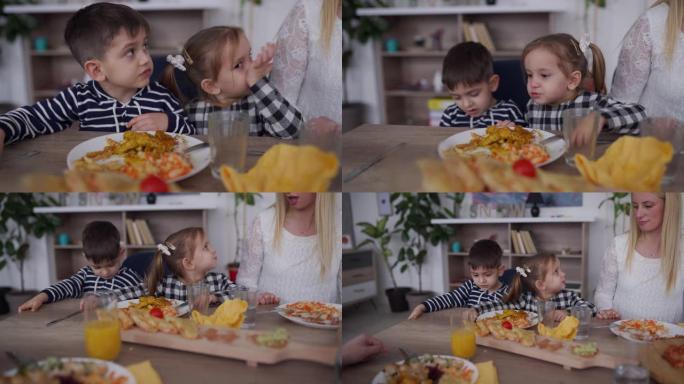 孩子们在朋友家中与父母共进午餐时吃美味的食物