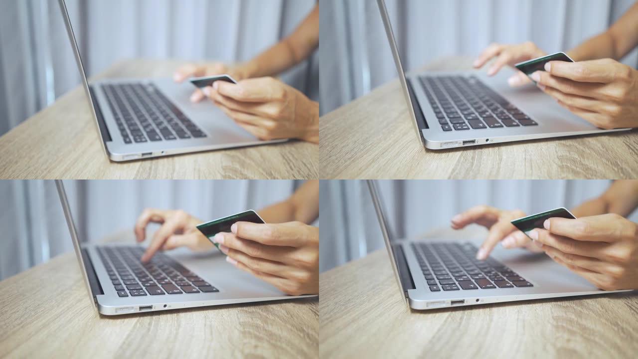 网上购物概念。女人手握信用卡并使用笔记本电脑