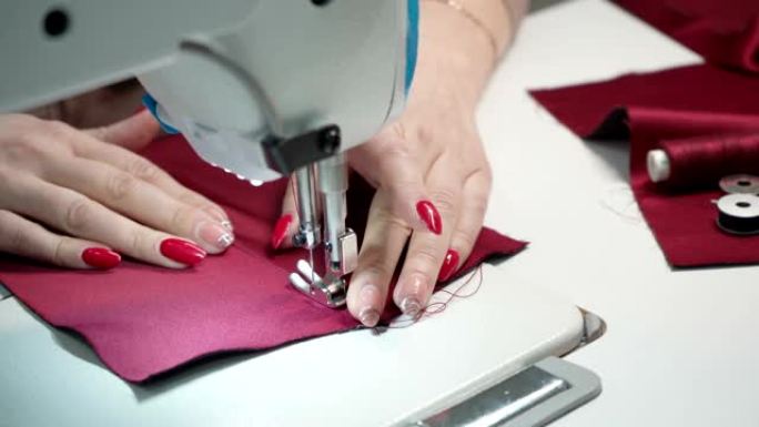 裁缝女装的拍摄电动缝纫机红色剪指甲劳作