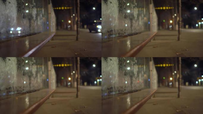 秋天晚上，城市街道上有冰冻玻璃的空公交车站候车亭。