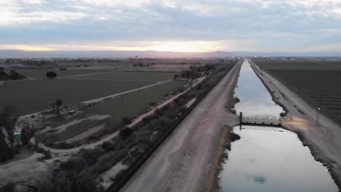 从墨西哥分隔开亚利桑那州和加利福尼亚州的国际边界墙的日落无人机视图