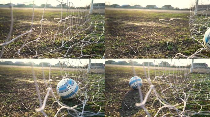 被撕裂的足球网的特写镜头。足球通过网。旧门足球场。