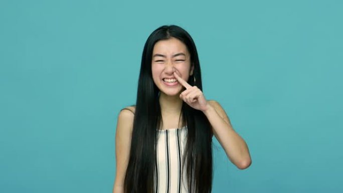 有趣的疯狂亚洲女人，长长的黑发露出舌头，拔出鼻屎，挖鼻子