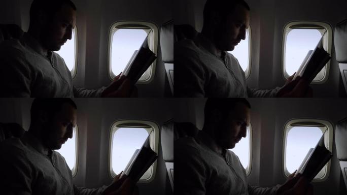 年轻人在机舱里阅读杂志