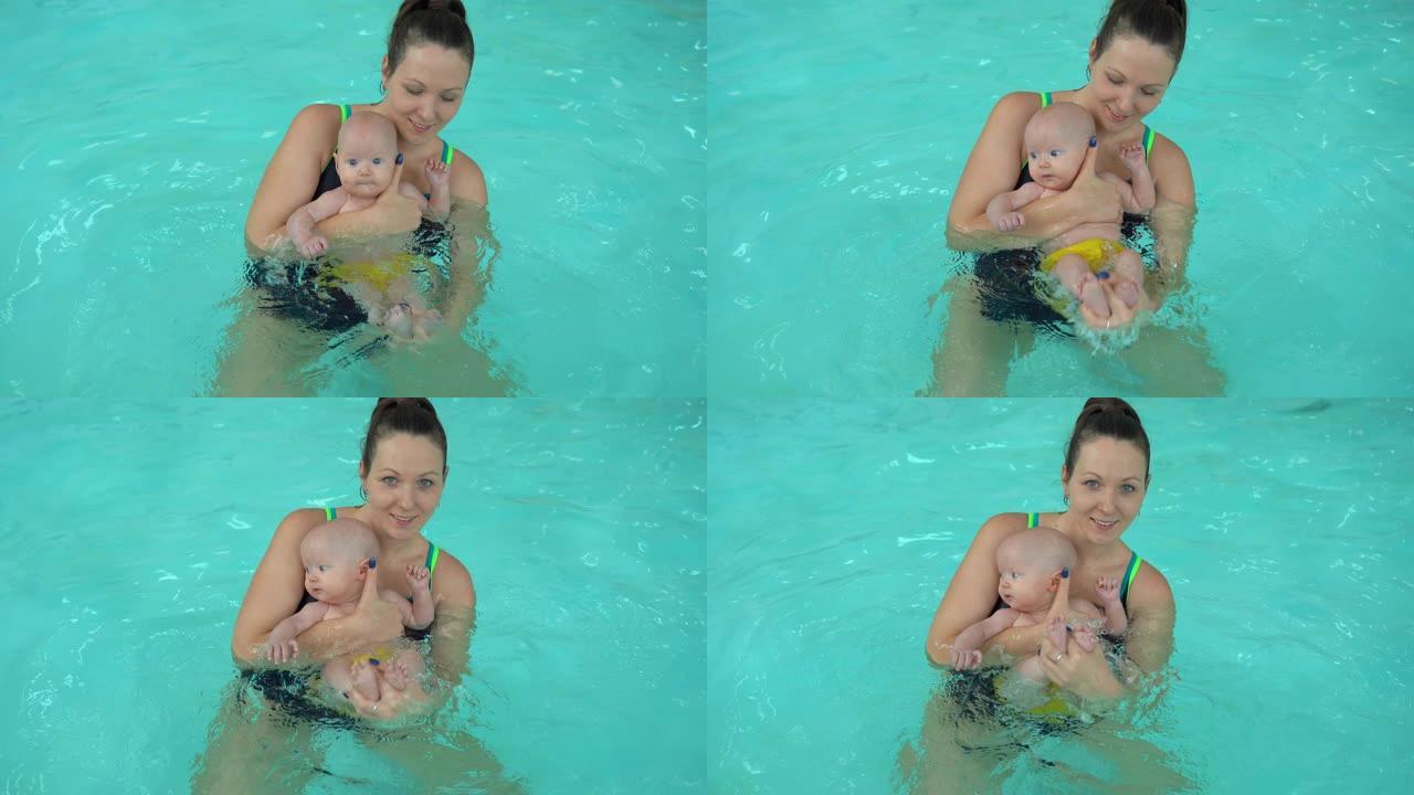 年轻的妈妈和她的小女儿在游泳池里做水手术。新生儿健康用水程序