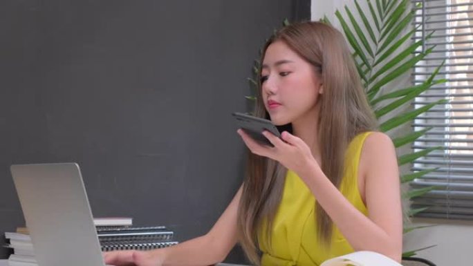 4k uhd迷人的亚洲女性商务女性黄色休闲装享受笔记本电脑办公背景下的日常工作
