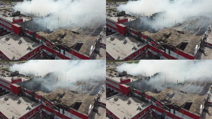 燃烧的工业建筑。烟雾，倒塌的屋顶，鸟瞰图