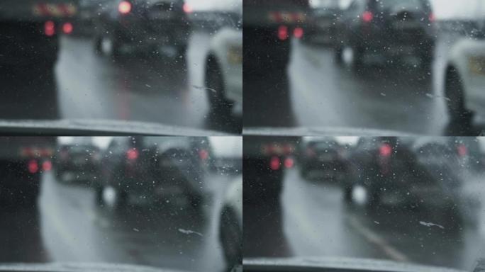 从驾驶室内部到挡风玻璃的视图。专注于前景。暴风雪期间，汽车在赛道上行驶。冬季白天降雪。交通恶劣的天气