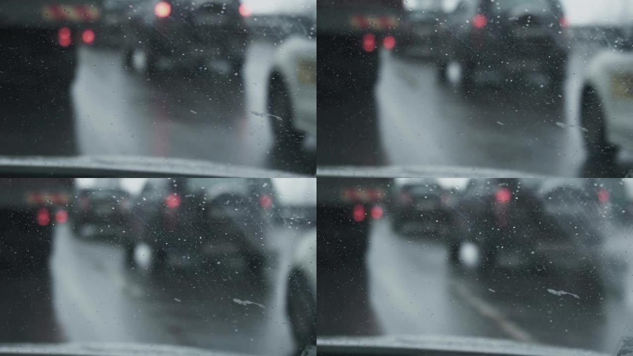 从驾驶室内部到挡风玻璃的视图。专注于前景。暴风雪期间，汽车在赛道上行驶。冬季白天降雪。交通恶劣的天气