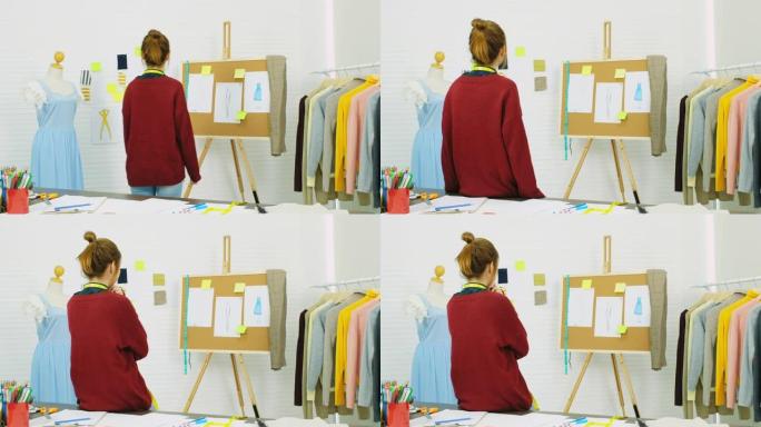 亚洲女性时装设计师在她的工作室《亚洲小企业概念》中看着黑板上的素描和素描