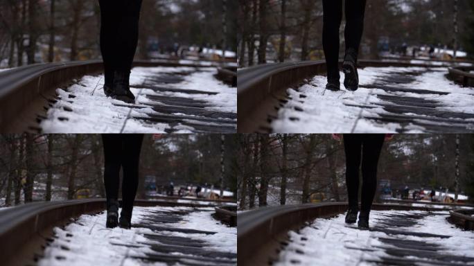 冬天，一个女孩的腿沿着旧铁轨行走。慢动作