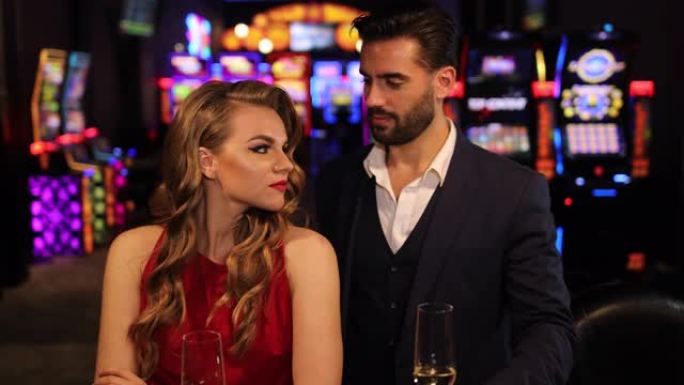 美丽的年轻夫妇在赌场调情