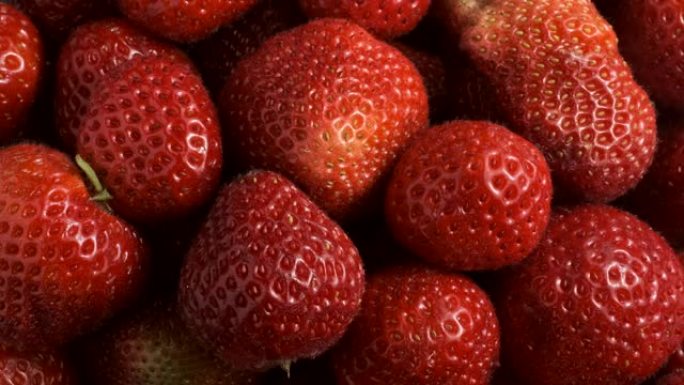多汁草莓的慢动作旋转。俯视图，旋转360度，极端特写。