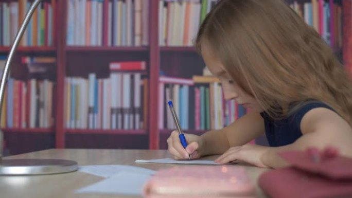 女学生用笔在书架背景纸上写字。学生女孩在舒适的办公室在家书柜背景下写作业。