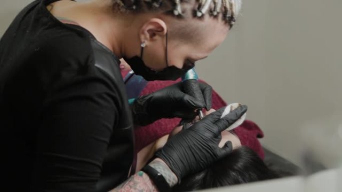 专业的永久化妆师用纹身机做永久眉毛化妆
