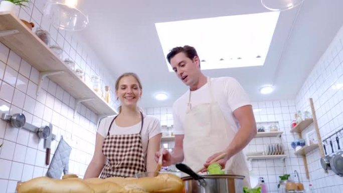 年轻夫妇博客教授拍摄关于厨房烹饪的视频食物博客