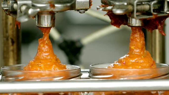 蔬菜罐头加工自动线。茄子酱制造商。将番茄酱装瓶在玻璃罐中。罐装厂输送带。能制造工艺。