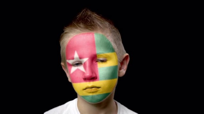 多哥足球队的伤心球迷。脸上涂着民族色彩的孩子。