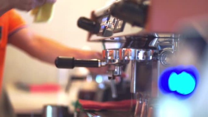 咖啡师将咖啡从机器滴入杯子。