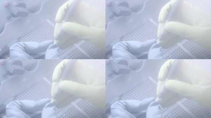 牙科技师在牙科实验室使用喷砂机抛光人造陶瓷牙齿。专业戴手套，手拿假牙，用喷砂机打磨