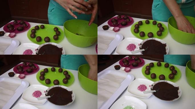 一个女人用手滚动饼干团，然后将它们放在盘子上。团块是棕色的，由饼干和可可屑制成，并添加黄油。盘子旁边