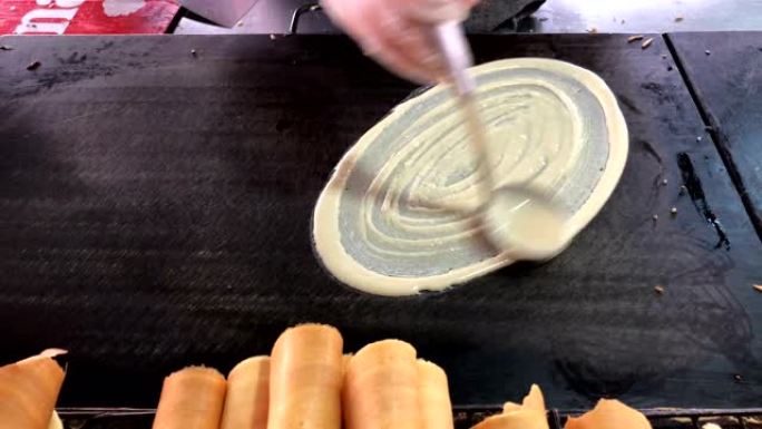 美味的紫薇卷或软华夫饼卷泰国甜点煎饼，配猪排、奶酪和酱汁。泰国街头食品中夹着奶油冻的卷煎饼