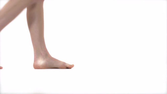 近距离演示视频赤脚女性的腿行走。孤立，在白色背景上。纯洁的概念
