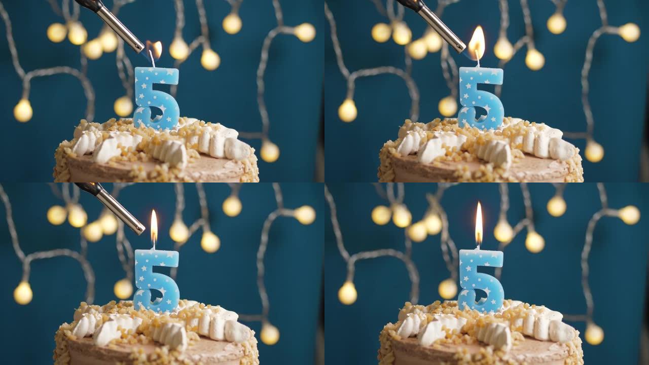 蓝色背景上有5个数字蜡烛的生日蛋糕。蜡烛着火了。慢动作和特写视图