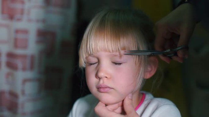 一个女孩在头上剪头发的特写镜头。