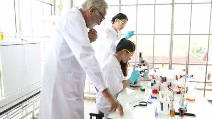 医学研究和科学家正在实验室中使用显微镜，片剂和试管，微量移液器和分析结果。