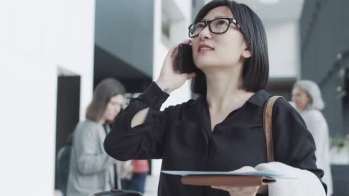 带登机牌的亚洲女子在候机室用手机聊天