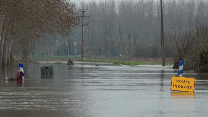 道路上的水，被河流和危险路标淹没的道路