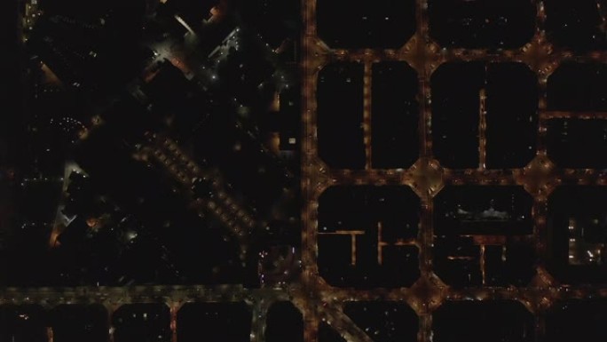 空中: 巴塞罗那头顶无人机拍摄夜间典型的城市街区，带有美丽的城市交通信号灯 [4K]