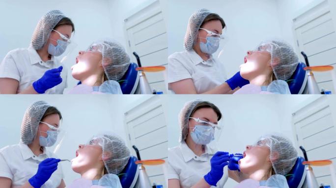 牙医在超声波清洗期间将棉塞放在女性口腔干牙中。
