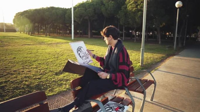 现代年轻时尚男性绘画艺术家在公园素描