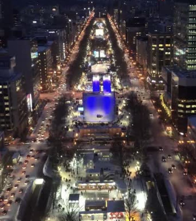 札幌电视塔大通公园札幌俯视图的垂直视频剪辑，冬季夜间商业区红绿灯