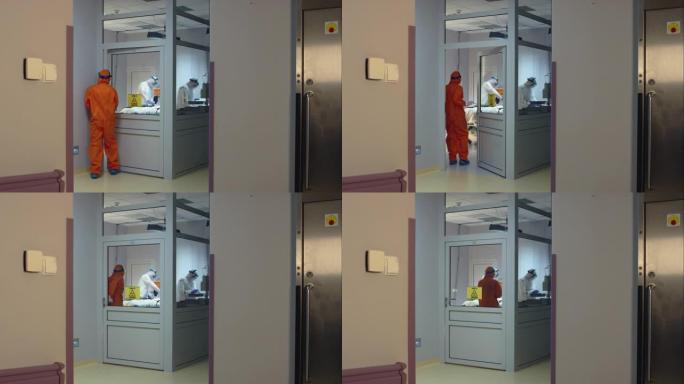 穿着橙色防护服的医生带着冠状病毒病人进入隔离房间