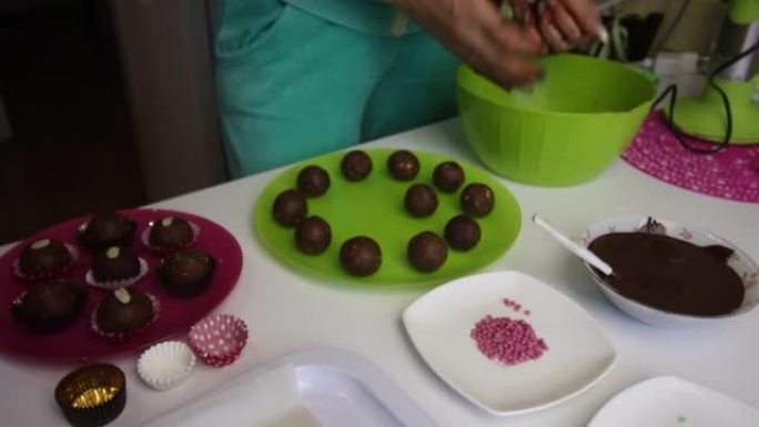 女人做土豆蛋糕。放大工作面。盘子旁边是蛋糕坯料，液体巧克力和彩色洒