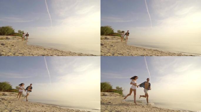这对年轻夫妇手牵手，在海滩上奔跑。慢动作