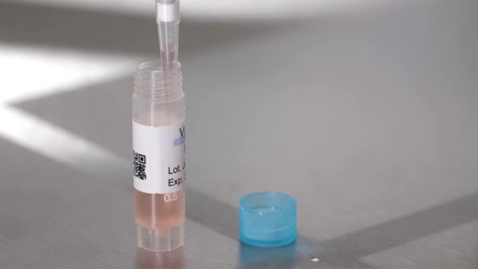 科学家使用移液管从瓶子中取出液体