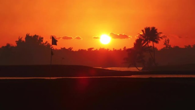 热带岛屿的高尔夫球场，美丽的日落与棕榈树剪影视频