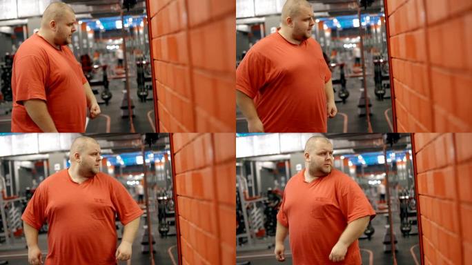 超重男性检查他的减肥进度看着镜子反射