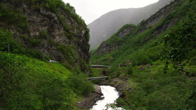 弗拉姆巴纳火车在挪威弗拉姆的弗拉姆铁路上。夏季4k挪威的山脉和瀑布。