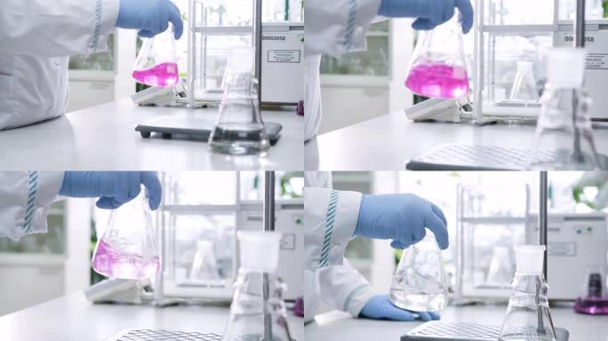 化学家摇动液体和粉红色化学物质变得清晰