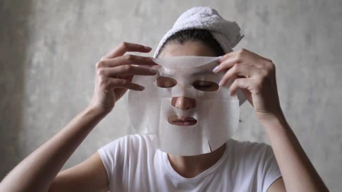 化妆品天然面膜抗衰老和面部皱纹。一名年轻女子在毛巾上敷面膜滋润脸部