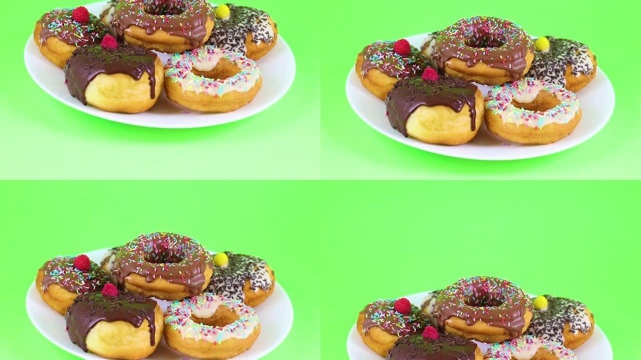 美味的甜甜圈上釉有白色和黑色巧克力，绿色屏幕上有装饰面包屑