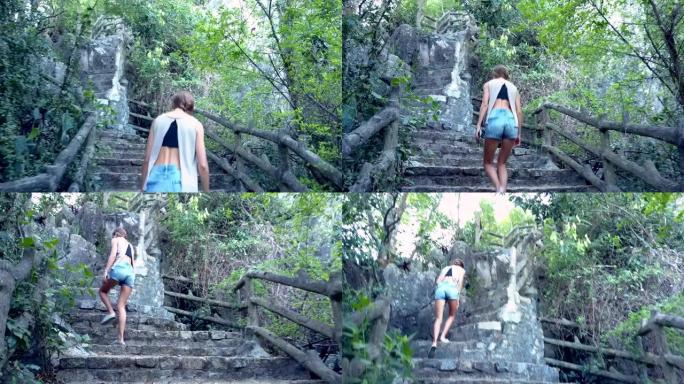 穿着短裤的低角度镜头女孩在山上走上石阶