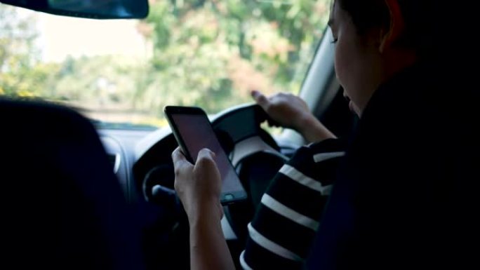 亚洲年轻女子在智能手机上使用Google Maps应用程序在开车时搜索方向。在运输中使用技术的概念。