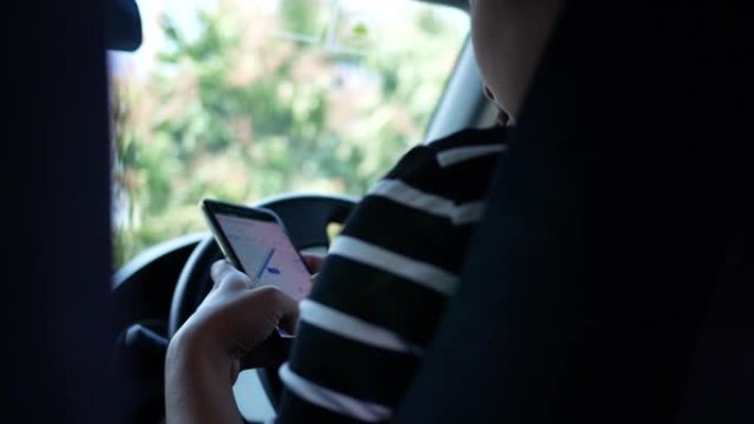 亚洲年轻女子在智能手机上使用Google Maps应用程序在开车时搜索方向。在运输中使用技术的概念。